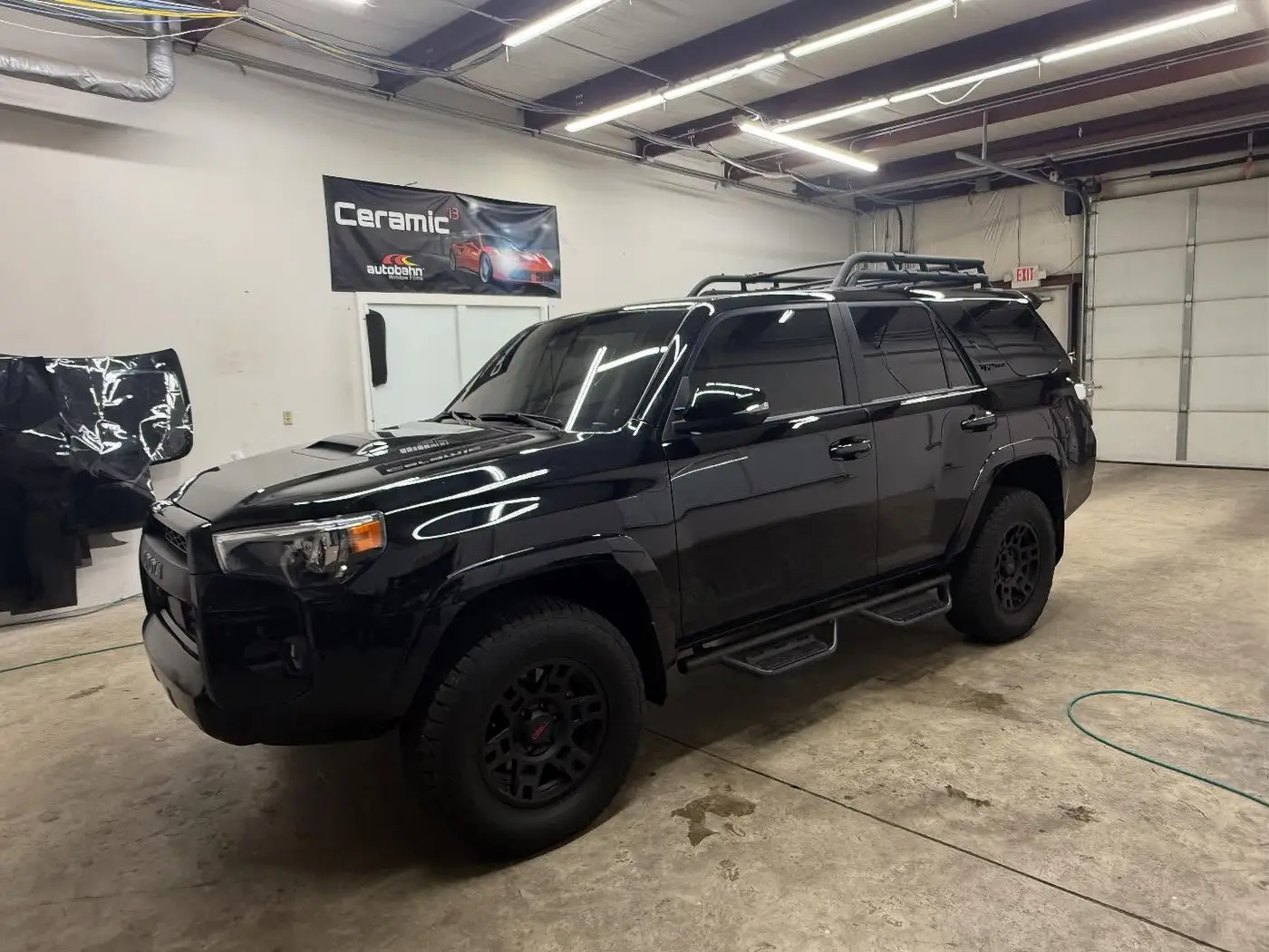 Black Toyota 4Runner with full tint inside the shop