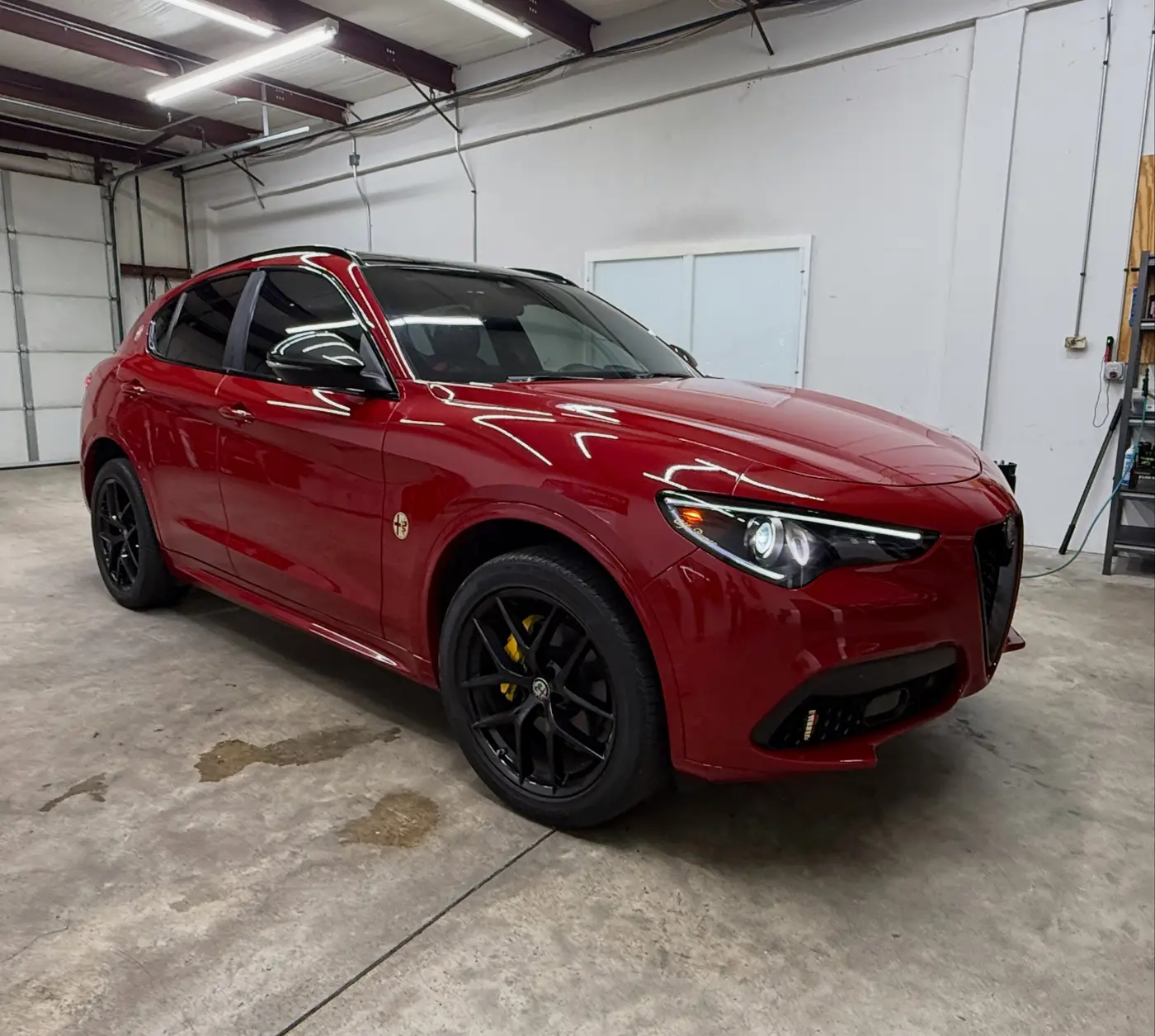 Red Alfa Romeo Stelvio with tinted glass inside the shop