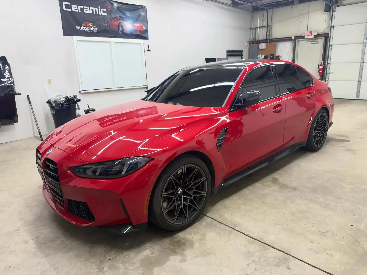 Red BMW M3 with fresh window tint inside the Tint-Factory shop in Dayton, Ohio